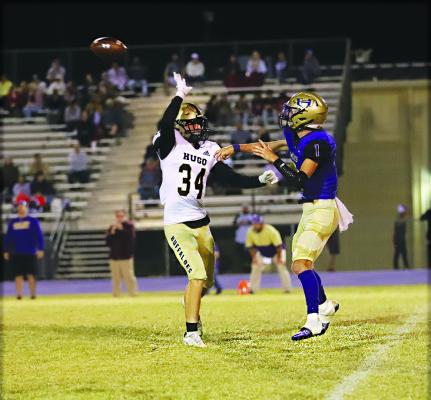 BUFFALO DEFENDER PIERSON EVANS forces Heavener’s quarterback to hurry his pass during District 2A-6 football action Thursday in Heavener. The Buffaloes hammered the Wolves, 62-39 to solidify their third place in the District. Hugo News Photo / KELLI STACY
