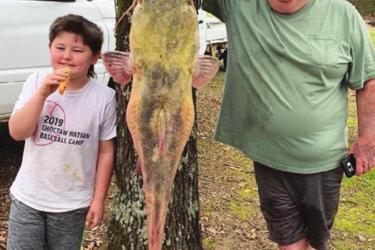 ABOVE: Earl Blagg Austin Potter and his papa, Ron Potter III, proudly pose next to the 54-pound catfish they caught on a jugline at Hugo Lake.