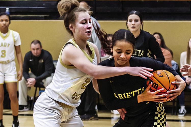 CALLISTA KELLEY plays some “get in your face defense” against a member of the Marietta Lady Indians basketball team in the District Tournament Friday. Kelley scored seven points for the Lady Buffs. Hugo News Photo / Bobby Hamill