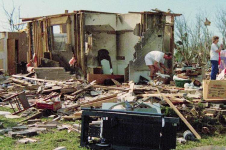 Friends help a family shift through the debris after an April 26, 1991 tornado hit Oologah, Okla. ©1991 and 2021 photo by Millie Moseley, Oologah Lake Leader